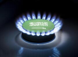 Burning gas burner of a home stove in the middle of which is the flag of the country of Saudi Arabia. Gas import and export delivery concept, price per cubic meter, transit, background photo