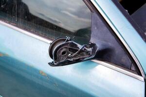 Broken car mirror on a car. Vandalism and hooliganism. Close-up photo