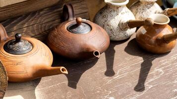 Clay teapots with long spouts and lids. Clay dishes. Copy space for text photo