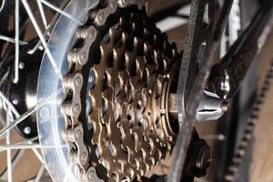 Gearshift on mountain bike MTB, chain moves on rings. Changes speeds. Shift gears on bicycle crank. Work of chain drive chainset. Front derailleur. Macro closeup low angle shot. Wheel spins and turns photo