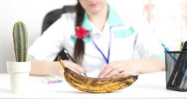 Black banana in the foreground in the office of a doctor of a sex therapist. The concept of the problem in men is a weakening of erectile dysfunction, a weak erection, a problem with potency photo