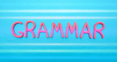 Grammar word in red letters on a blue background. Grammar and language learning concept, punctuation photo