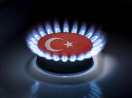 Burning gas burner of a home stove in the middle of which is the flag of the country of Turkey. Gas import and export delivery concept, price per cubic meter, transit, background photo