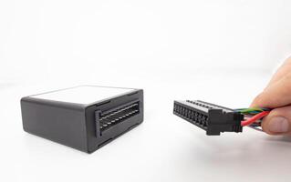 A man connects an electrical connector to an electronic climate control unit in a car. adjustment of comfortable temperature in the car, copy space photo