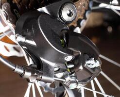 Gearshift on mountain bike MTB, chain moves on rings. Changes speeds. Shift gears on bicycle crank. Work of chain drive chainset. Front derailleur. Macro closeup low angle shot. Wheel spins and turns photo