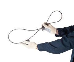 Auto locksmith holding a used timing belt on a white background, isolate. Regulations for replacing belts and rollers of the engine, industrial photo