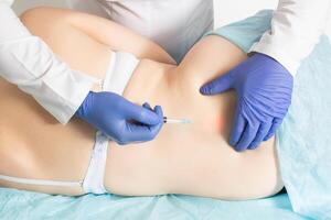 The doctor gives a medical injection with pain medication and chondroprotective agent to restore the spine. Medical blockade for relieving inflammation and edema in the area of herniated disc photo