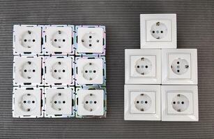 Many modern electrical sockets on a gray background, close-up. Rise in the price of electricity price per kilowatt, saving electricity, close-up photo