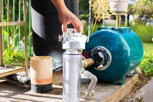 Water supply system from a well in a country house. New water filter. Hydraulic accumulator for storing water volume. Replacing a new water filter. photo