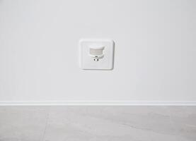 Modern motion sensor for turning on and off the light on the ceiling. photo