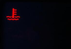 Red indicator of car engine coolant on a black background. Car overheating concept, copy space for text photo