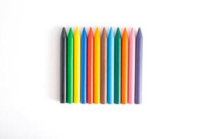 Multicolored wax crayons for drawing on paper and wood with a bright saturated color on a white background, isolate photo