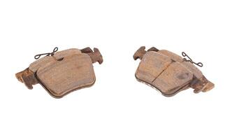 Old worn out brake pads from a car on a white background, isolate, close-up. Quality of friction linings, modern auto parts photo