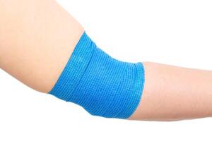 Blue elastic bandage on the elbow joint on the arm, white background, isolate. Elbow fixation concept for sports, orthopedic photo