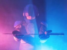 Cyberpunk future concept. Bionic cyborg police officer with short samurai sword stands in dark with smoke, fume. Halfman robot looks at camera. Futuristic science fiction scene. photo