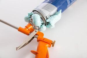 Construction foam gun with a defective cylinder. Foam bottle defect, close-up photo