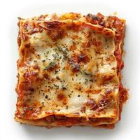 A square of lasagna on a white surface, ready to be served. photo
