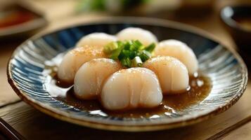 Close up of sushi with soy sauce and garnishes, served on a plate with decorative bowls in the background. photo