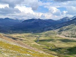 A view of a valley and mountains from a mountain top photo