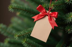 Close up of a blank beige gift tag with a red satin bow hanging on a green Christmas tree branch. Perfect for holiday greetings, gift ideas, or festive decoration themes photo