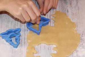 Top view of gingerbread cookies being made. Child baking with gingerbread cookie cutters. Traditional winter seasonal baking photo