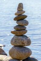 Pyramid of stones. Unstable balance of stone objects. Idyllic state of nature. photo