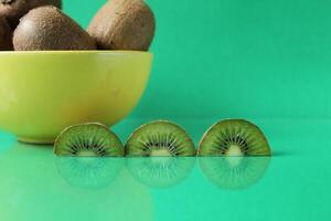 still life kiwi fruit in a yellow bowl plate and next to a kiwi copyspace slice photo