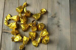 Scattering of candies in a wrapper on a gray background, top view, upper angle. Healthy candies photo