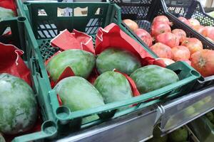 green mango in a plastic box in a store. Fruit display in the store photo