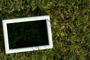 White frame with black space for text on freshly greenery grass photo