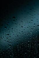 raindrops on a window, with a dark background photo