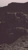 A large rock formation in the middle of a desert video