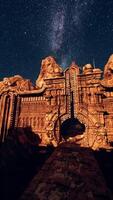 A large rock structure under a star filled sky video