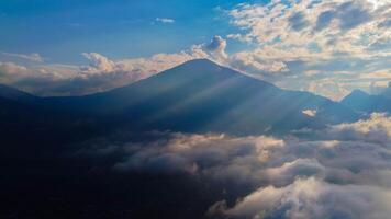 Experience breathtaking aerial views of the rolling hills in Sembalun, at the foot of Mount Rinjani, with expansive savanna turning golden at sunrise. photo