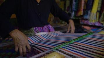 Colorful of Kain Tenun, an Indonesian traditional hand woven fabric from West Nusa Tenggara or Lombok, hanging for sale in Sade village as souvenirs photo