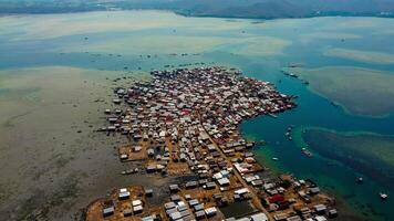Explore stunning aerial footage of the world's most unique at Bungin Island, densely populated island, nestled in vibrant blue waters with 3,000 residents in Nusa Tenggara Barat, Indonesia photo