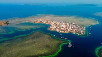 Explore stunning aerial footage of the world's most unique at Bungin Island, densely populated island, nestled in vibrant blue waters with 3,000 residents in Nusa Tenggara Barat, Indonesia photo