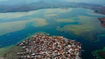 Explore stunning aerial footage of the world's most unique at Bungin Island, densely populated island, nestled in vibrant blue waters with 3,000 residents in Nusa Tenggara Barat, Indonesia photo