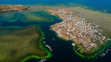 Explore stunning aerial footage of the world's most unique at Bungin Island, densely populated island, nestled in vibrant blue waters with 3,000 residents in Nusa Tenggara Barat, Indonesia photo