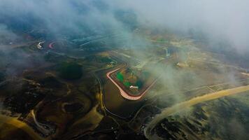 Experience stunning aerial views of hills behind the Mandalika circuit in Lombok, with a breathtaking sunset atmosphere as the camera glides through the clouds. photo