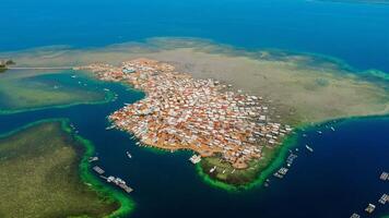 Explore stunning aerial footage of the world's most unique at Bungin Island, densely populated island, nestled in vibrant blue waters with 3,000 residents in Nusa Tenggara Barat, Indonesia photo