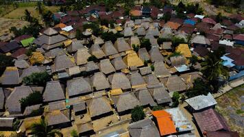 An aerial view of Sade Village in Lombok reveals lush farmland and densely populated homes under the bright midday sun, showcasing vibrant community life. photo