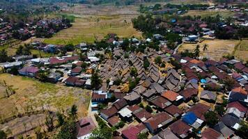 An aerial view of Sade Village in Lombok reveals lush farmland and densely populated homes under the bright midday sun, showcasing vibrant community life. photo