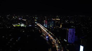 A busy city street with many people and vehicle. Concept of hustle and bustle, with people walking and cars driving in a busy urban environmen photo