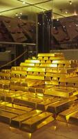 Golden bars of gold. There are many bars of gold in the image. The bars are stacked on top of each other. photo