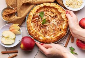 Apple galette preparation with fresh ingredients and spices on a kitchen countertop photo