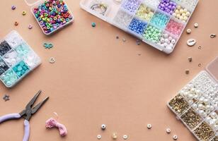 Crafting with colorful beads on a flat workspace with tools and containers in bright daylight photo