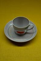 A cup in a saucer on a yellow background, top view. A coffee mug. Espresso Mug photo