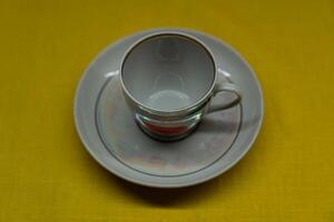 A cup in a saucer on a yellow background, top view. A coffee mug. Espresso Mug photo