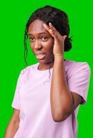 A woman expressing frustration while standing in front of a bright green background photo